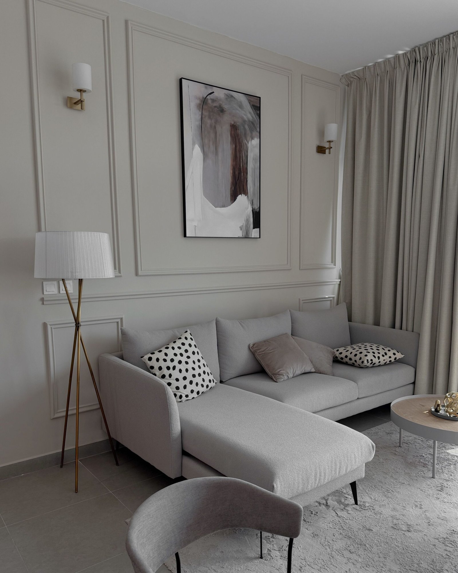 Nowoczesny salon ze ścianą akcentową w kolorze szałwiowym i beżową sofą