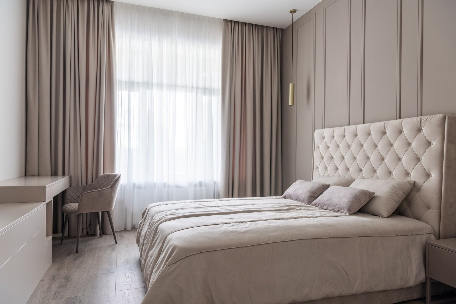 Elegancka aranżacja okna w sypialni z jasnymi zasłonami blackout i delikatną firaną
