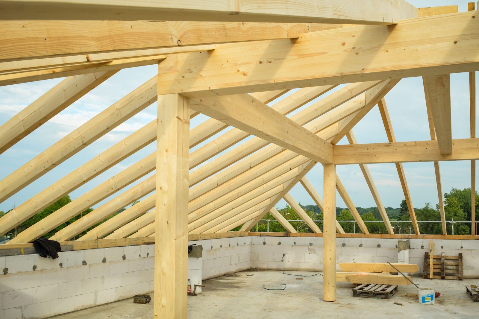 wooden roof truss construction site single family house roof membrane timber framing blue sky sunny day